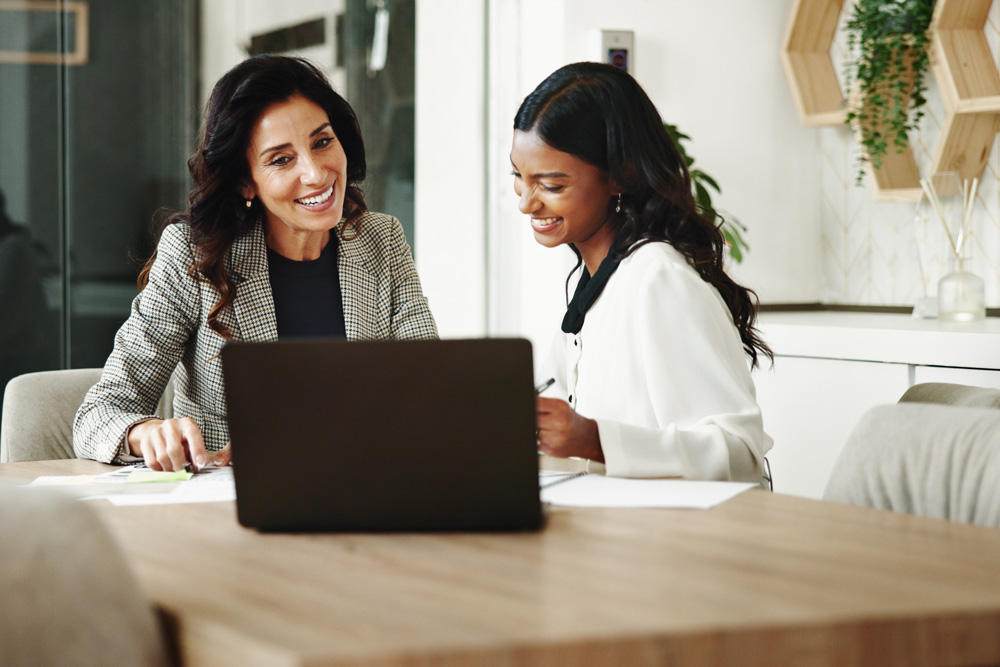 Mentor discussion with a laptop on a table